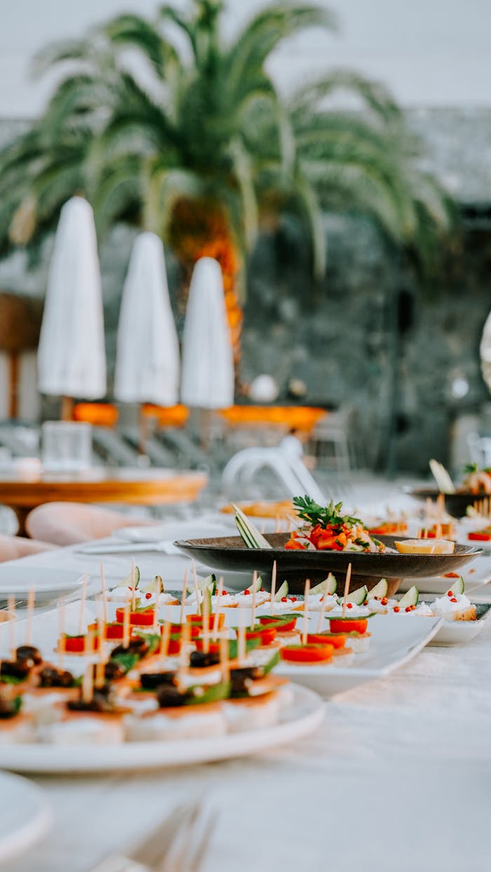 A beautifully set table with various gourmet finger foods at an outdoor party.