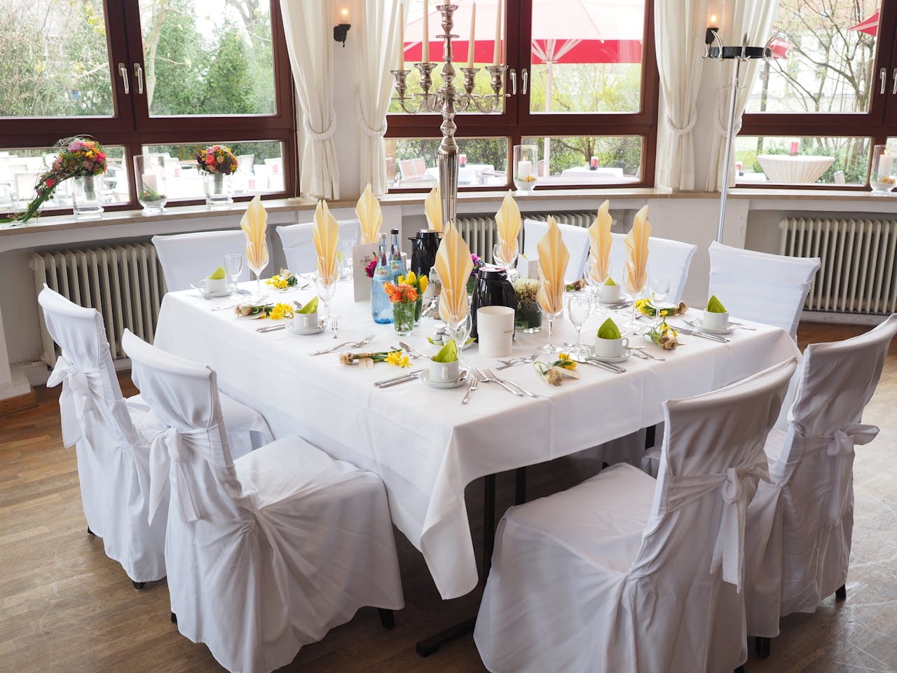 A beautifully set dining table in a well-lit room with white decor, perfect for celebrations.