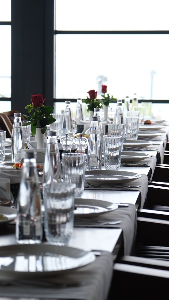 Chic table setup with glassware and red roses in a modern restaurant.